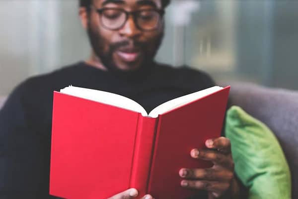 Man reading book - business school student learning from home